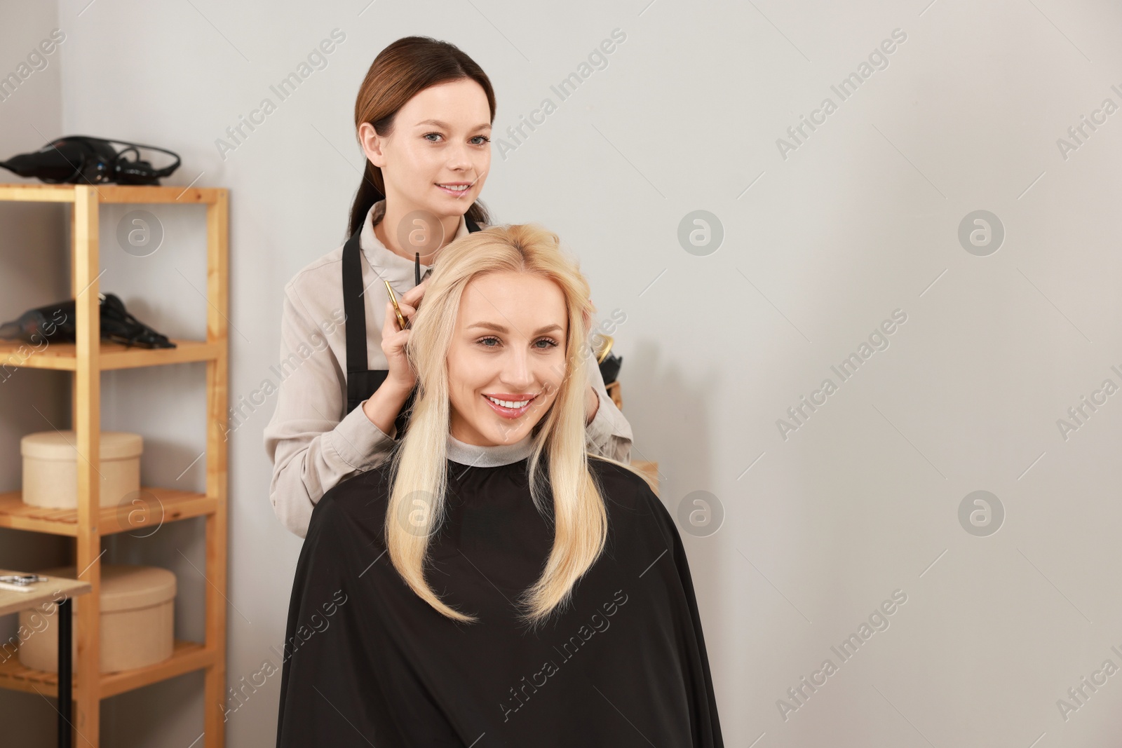 Photo of Hair cutting. Professional hairdresser working with client in salon