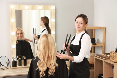 Photo of Hair cutting. Professional hairdresser working with client in salon