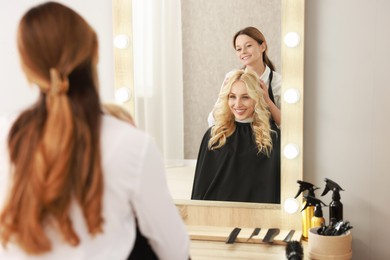 Photo of Hair cutting. Professional hairdresser working with client in salon, selective focus