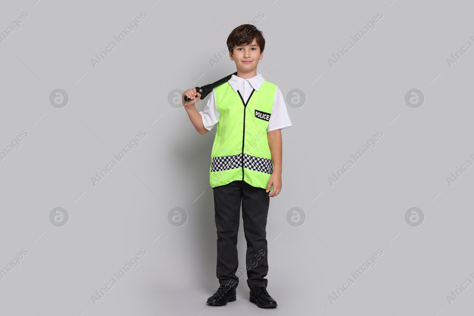 Photo of Boy pretending to be policeman on light grey background. Dreaming of future profession