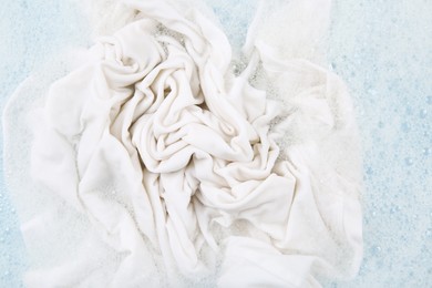 Photo of Washing laundry in water with foam, top view