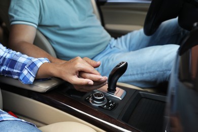 Lovely couple holding hands together while traveling by car, closeup