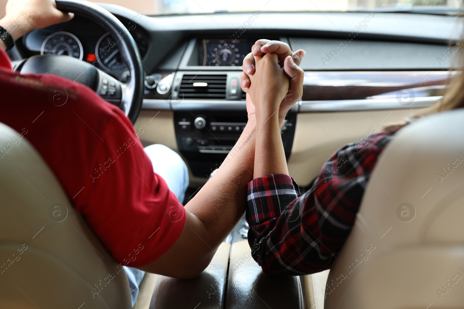 Photo of Lovely couple holding hands together while traveling by car, closeup