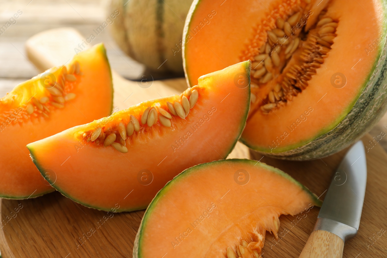 Photo of Cut ripe Cantaloupe melon and knife on table, closeup