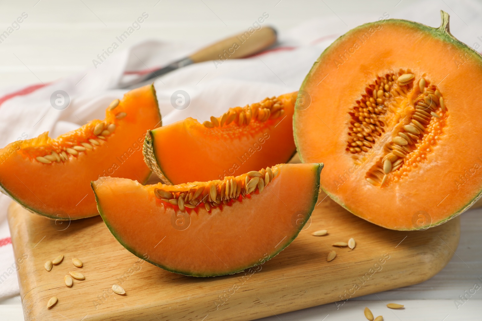 Photo of Cut ripe Cantaloupe melon on white table