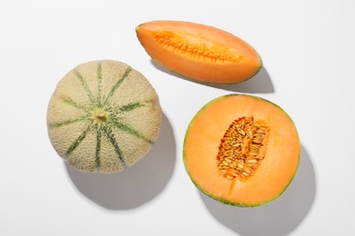 Photo of Pieces of fresh Cantaloupe melon on white table, flat lay