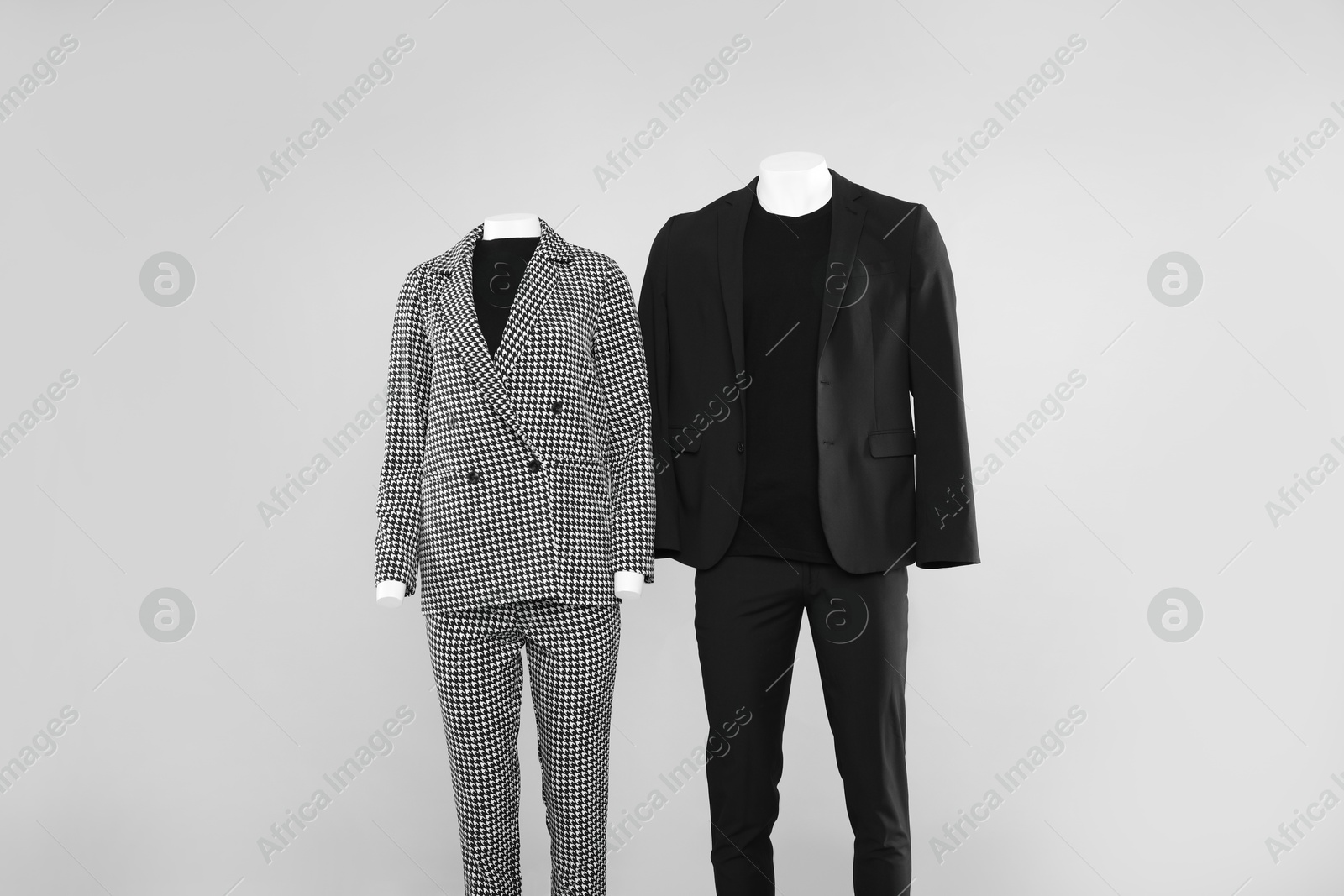 Photo of Female and male mannequins with stylish outfits on light background