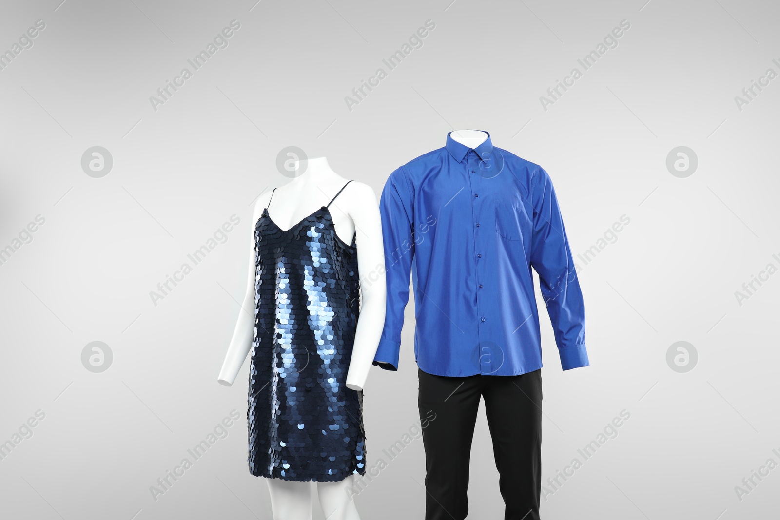 Photo of Female and male mannequins with stylish outfits on light background