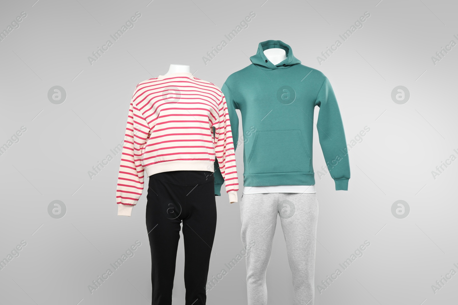 Photo of Female and male mannequins with stylish outfits on light background