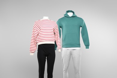 Photo of Female and male mannequins with stylish outfits on light background