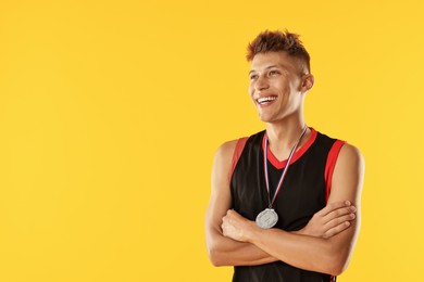 Photo of Happy winner with silver medal on yellow background. Space for text