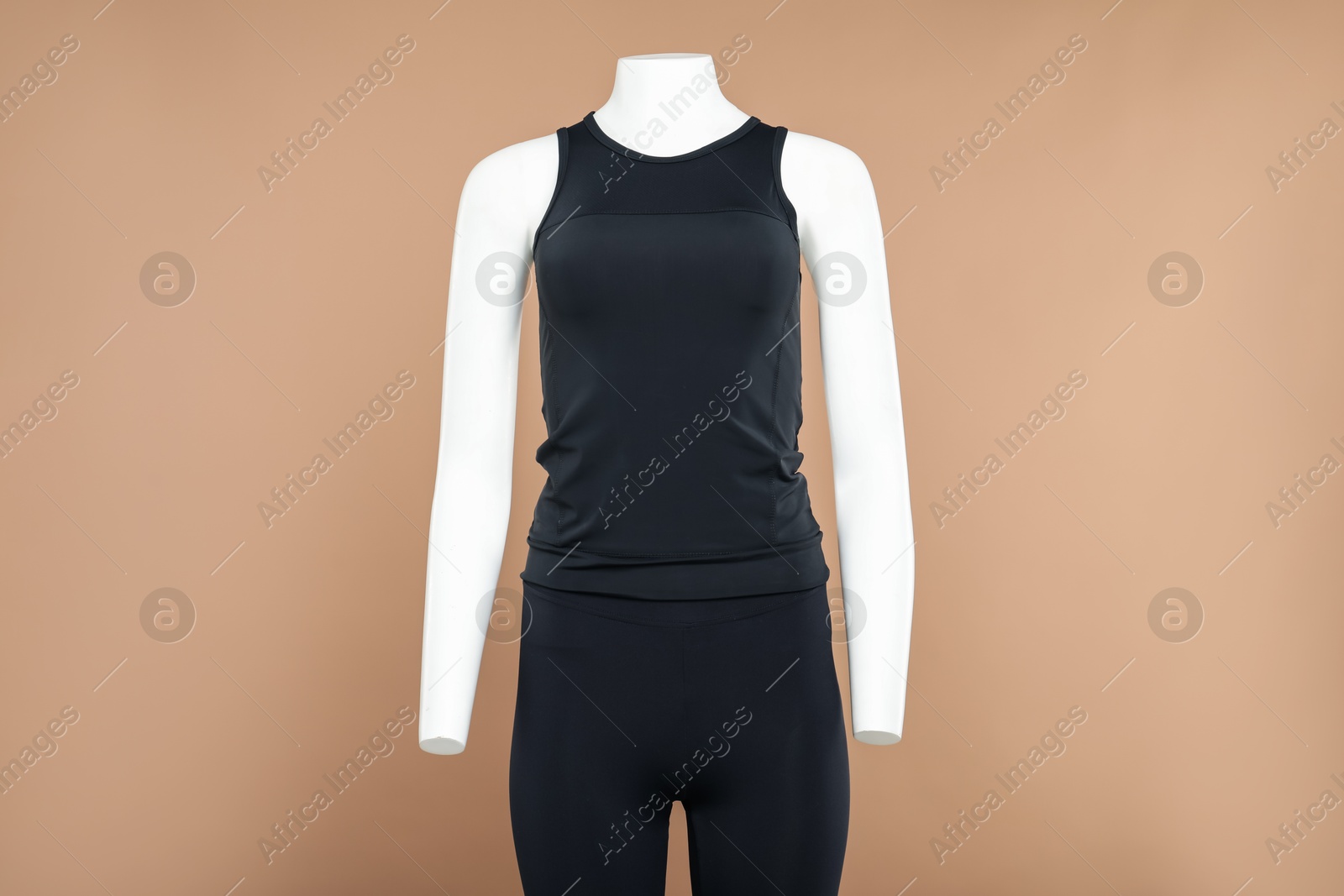 Photo of Female mannequin with stylish sports outfit on light brown background