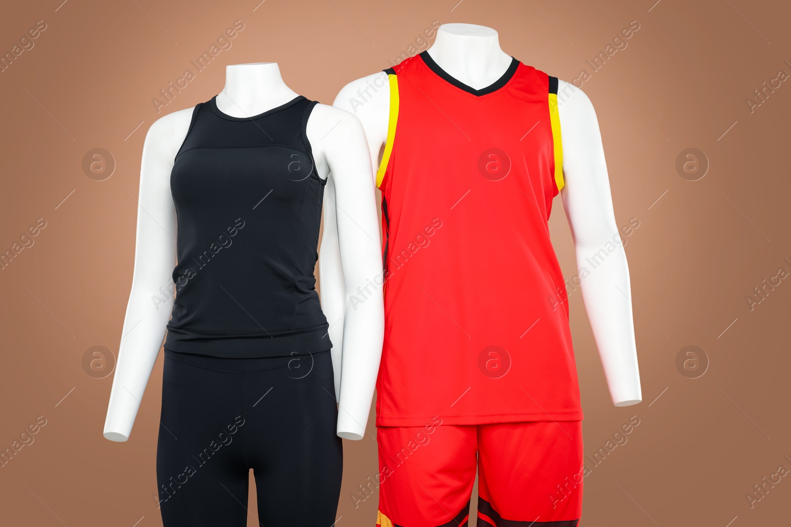 Photo of Female and male mannequins with stylish sports outfits on light brown background