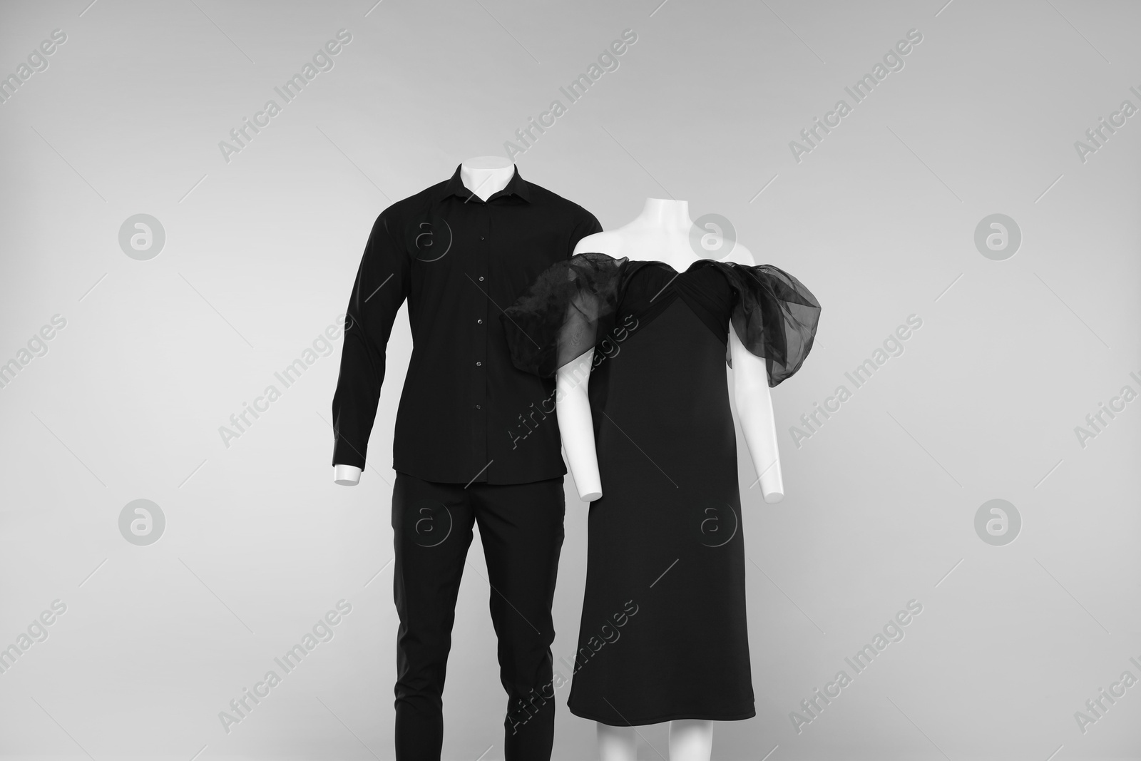 Photo of Female and male mannequins with stylish outfits on light grey background