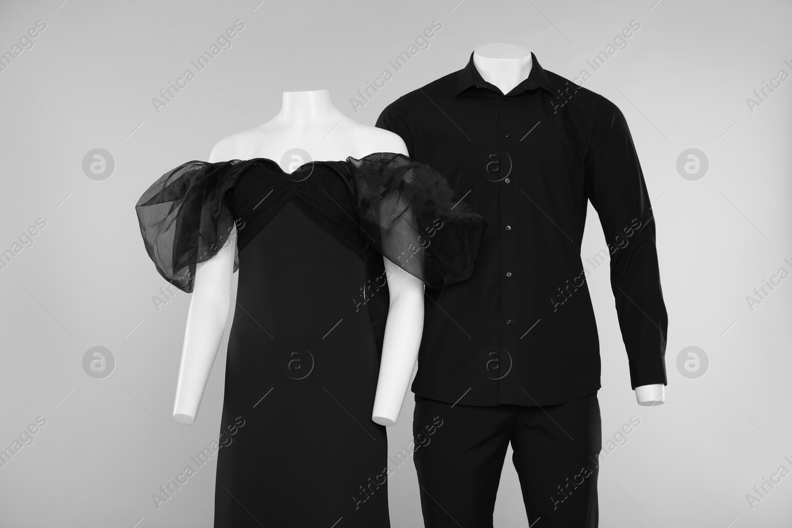 Photo of Female and male mannequins with stylish outfits on light grey background