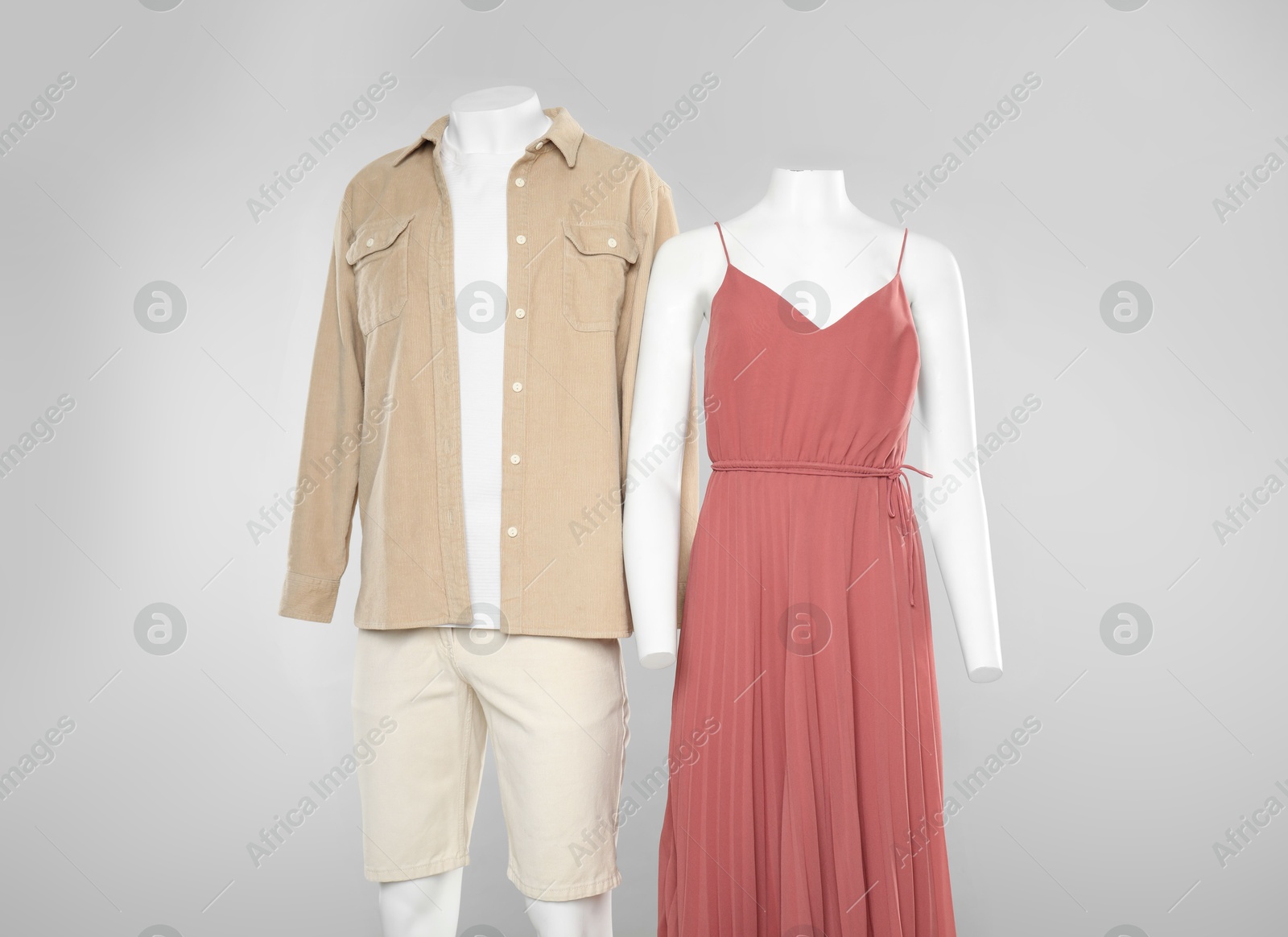 Photo of Female and male mannequins with stylish outfits on light grey background