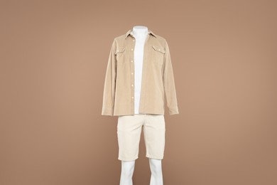 Photo of Male mannequin with stylish outfit on light brown background