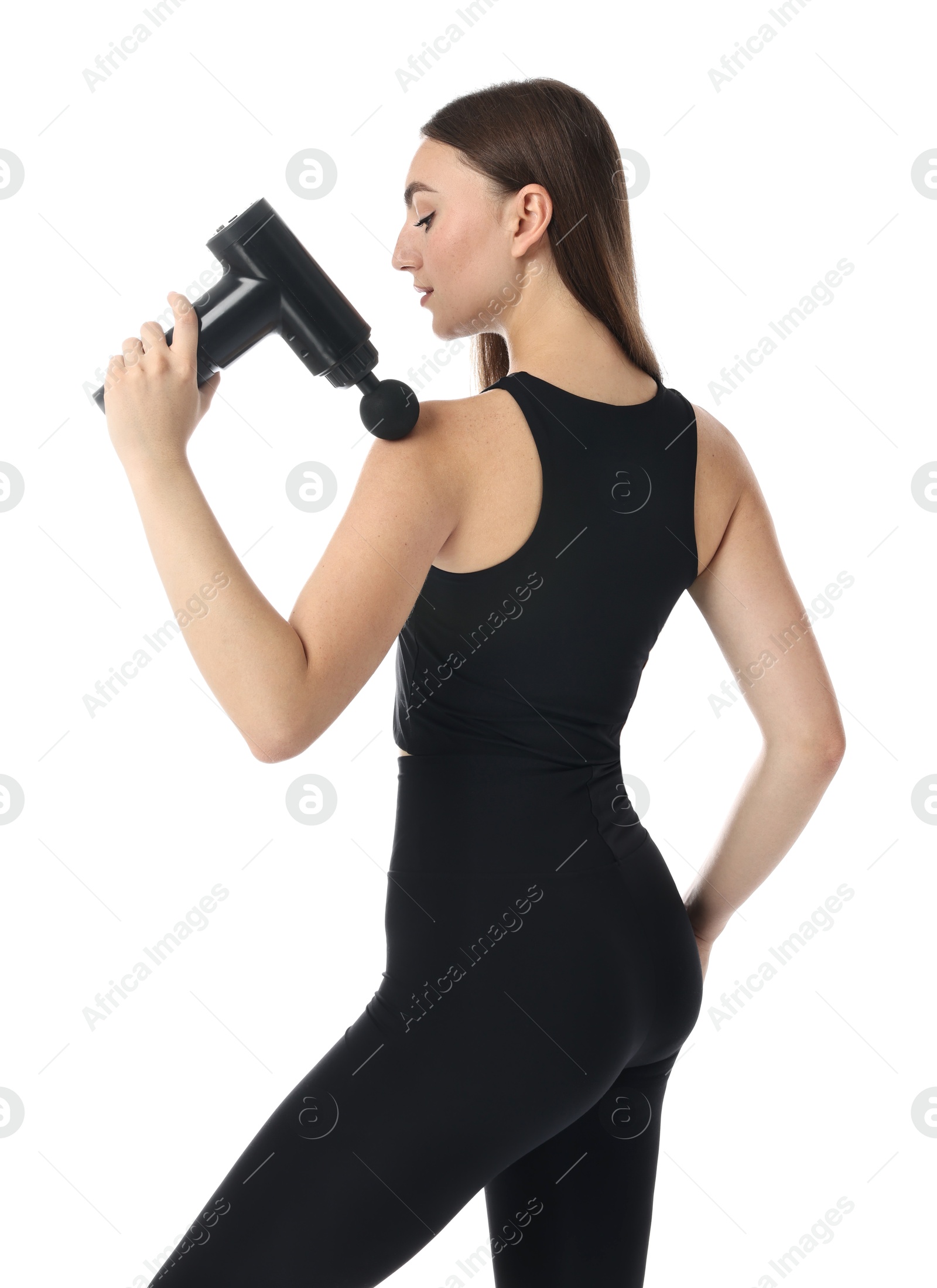 Photo of Young woman massaging her shoulder with percussion massager on white background