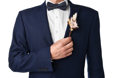 Photo of Groom in suit with stylish boutonniere on white background, closeup