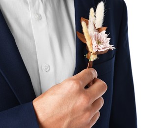 Photo of Groom in suit with stylish boutonniere on white background, closeup