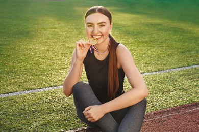 Photo of Happy winner with golden medal at stadium