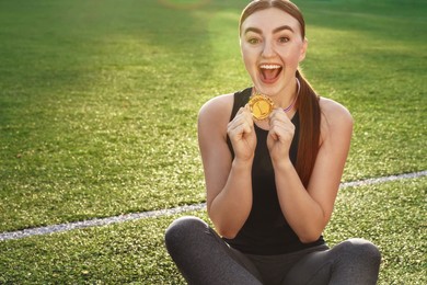 Photo of Happy winner with golden medal at stadium. Space for text