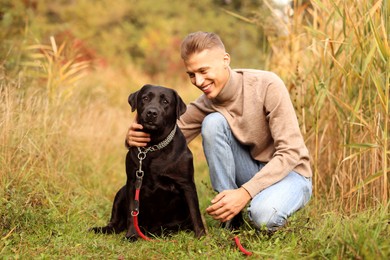 Photo of Smiling man with cute dog outdoors on autumn day