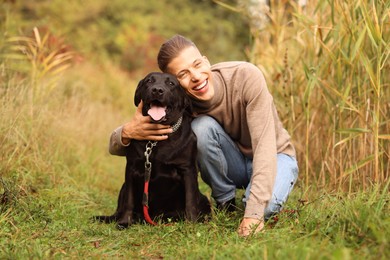 Photo of Smiling man with cute dog outdoors on autumn day