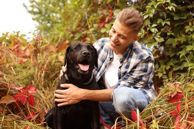 Smiling man with cute dog outdoors on autumn day