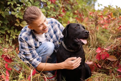 Smiling man with cute dog outdoors on autumn day