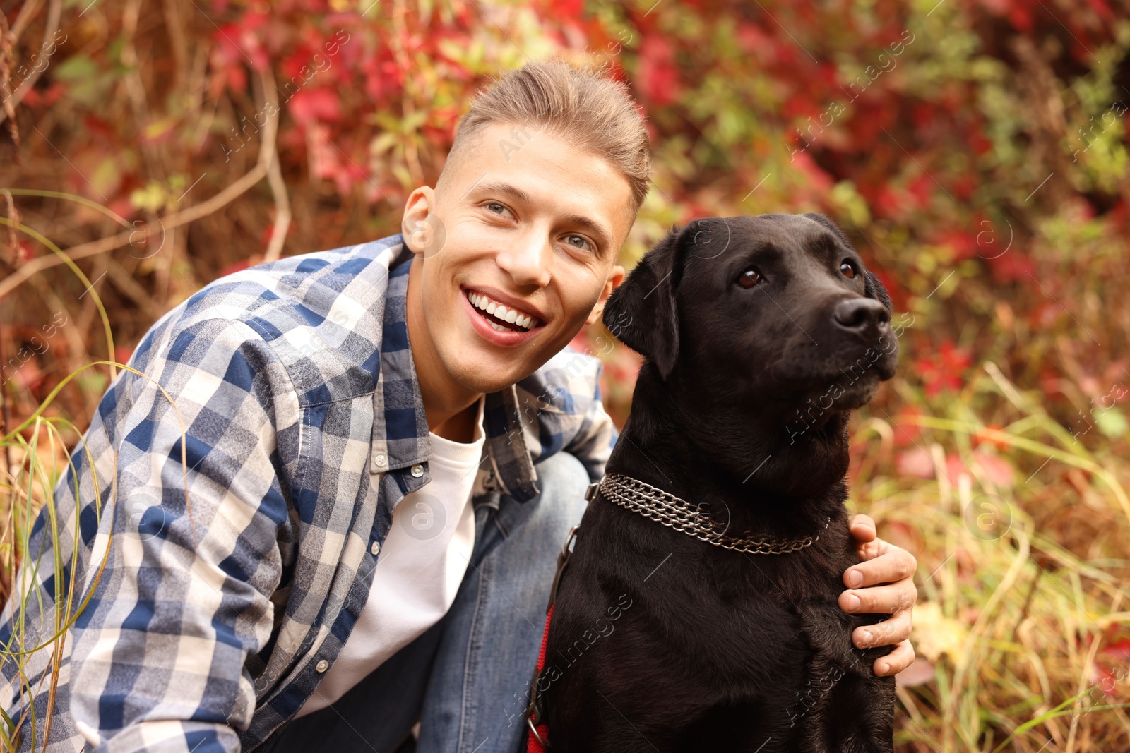 Photo of Smiling man with cute dog outdoors on autumn day