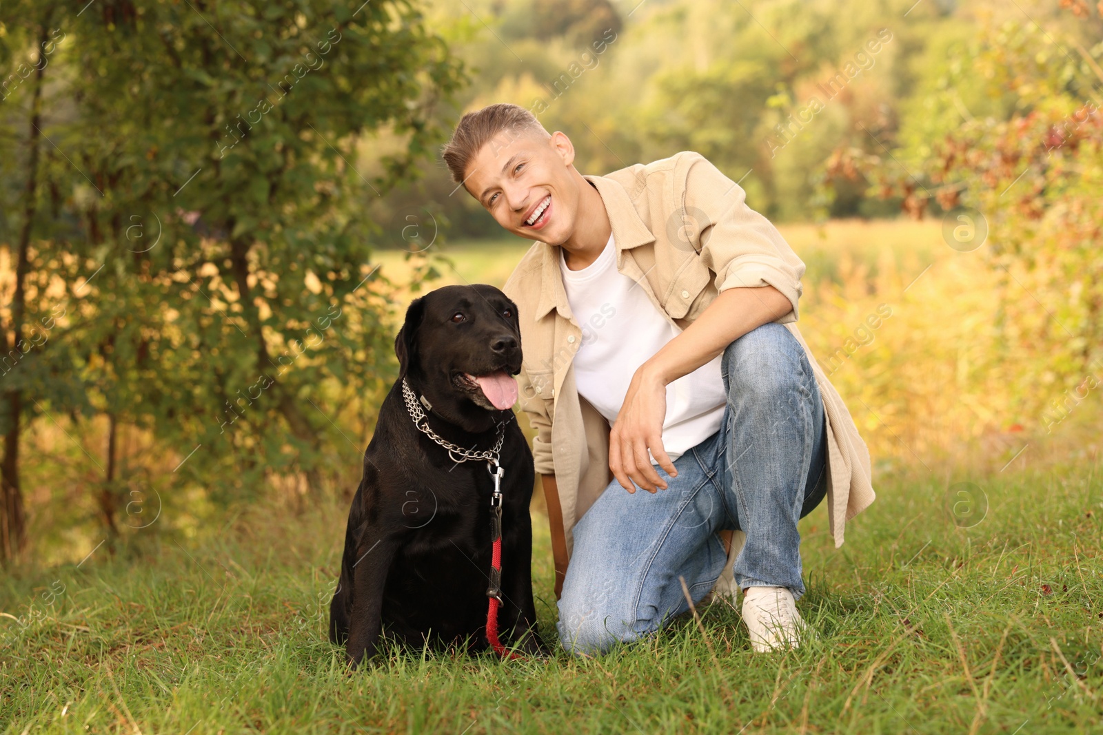 Photo of Smiling man with cute dog outdoors on autumn day