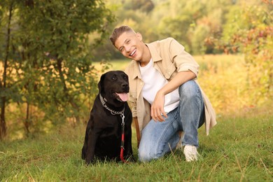 Photo of Smiling man with cute dog outdoors on autumn day