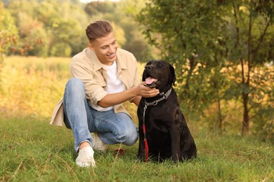 Photo of Smiling man with cute dog outdoors on autumn day