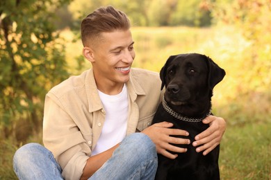 Photo of Smiling man with cute dog outdoors on autumn day