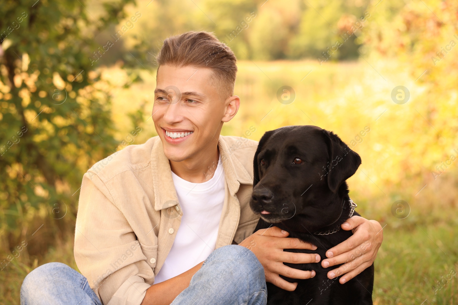 Photo of Smiling man with cute dog outdoors on autumn day