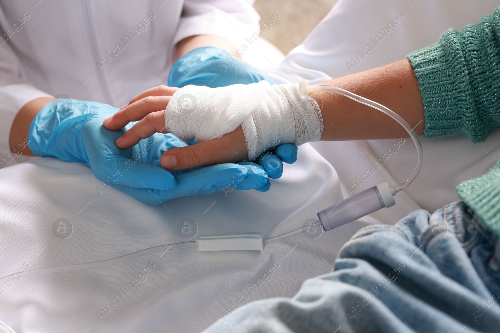 Photo of Doctor and child with IV drip in hospital, closeup