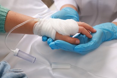 Photo of Doctor and child with IV drip in hospital, closeup