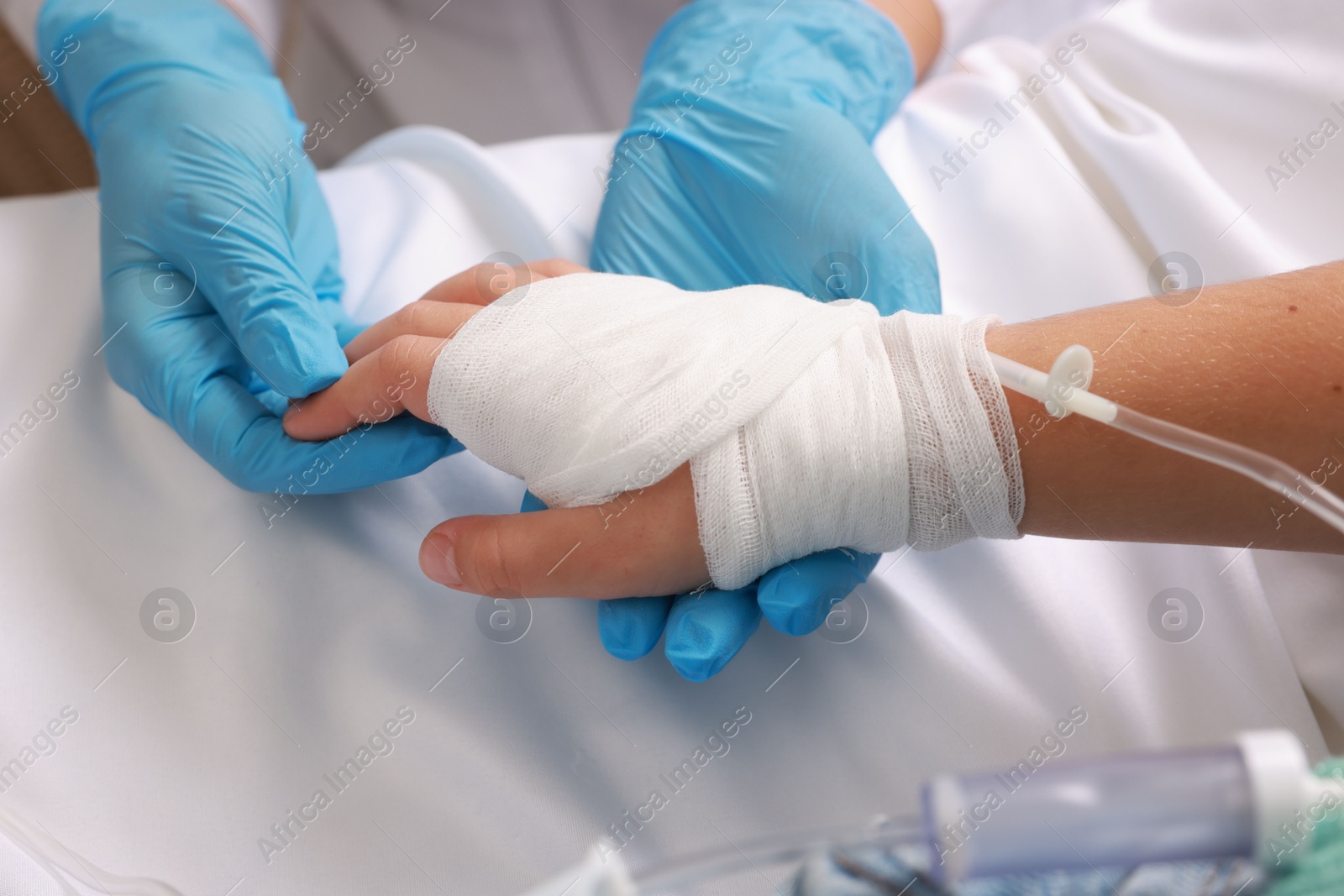 Photo of Doctor and child with IV drip in hospital, closeup