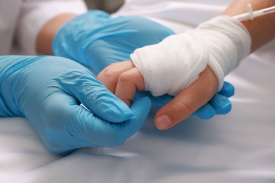 Photo of Doctor and child with IV drip in hospital, closeup