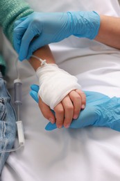 Photo of Doctor and child with IV drip in hospital, closeup