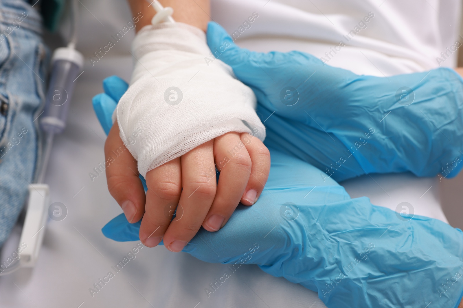 Photo of Doctor and child with IV drip in hospital, closeup