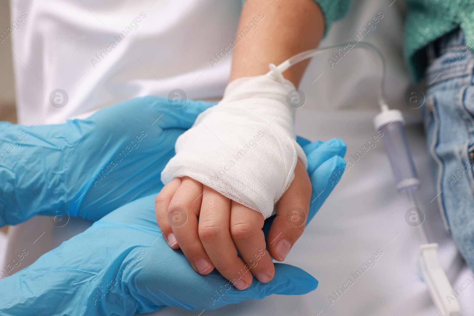 Photo of Doctor and child with IV drip in hospital, closeup