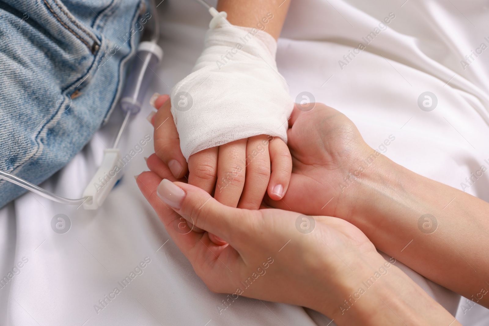 Photo of Doctor and child with IV drip in hospital, closeup