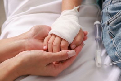 Photo of Doctor and child with IV drip in hospital, closeup