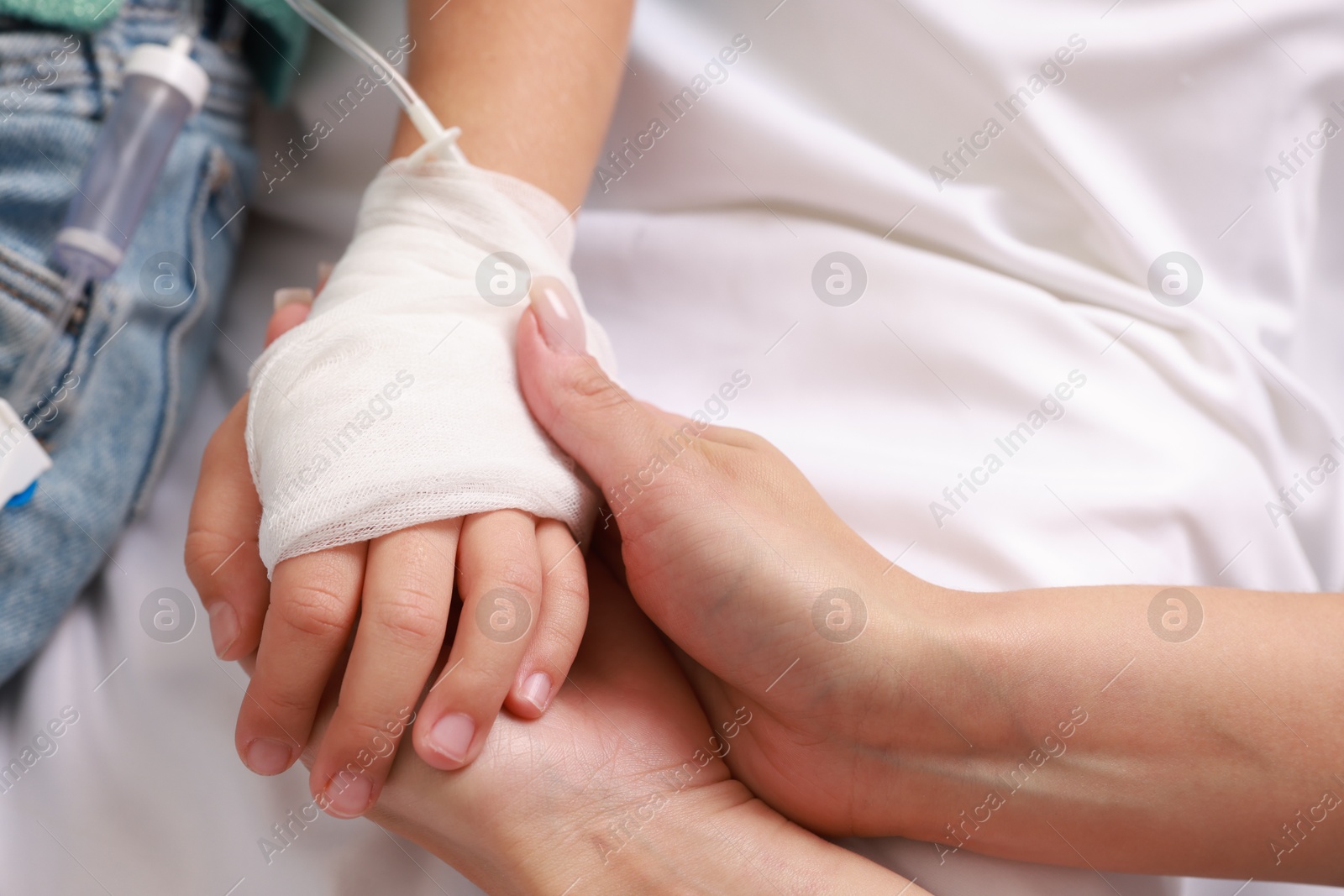 Photo of Doctor and child with IV drip in hospital, closeup