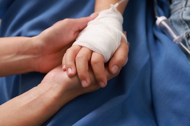 Photo of Doctor and child with IV drip in hospital, closeup