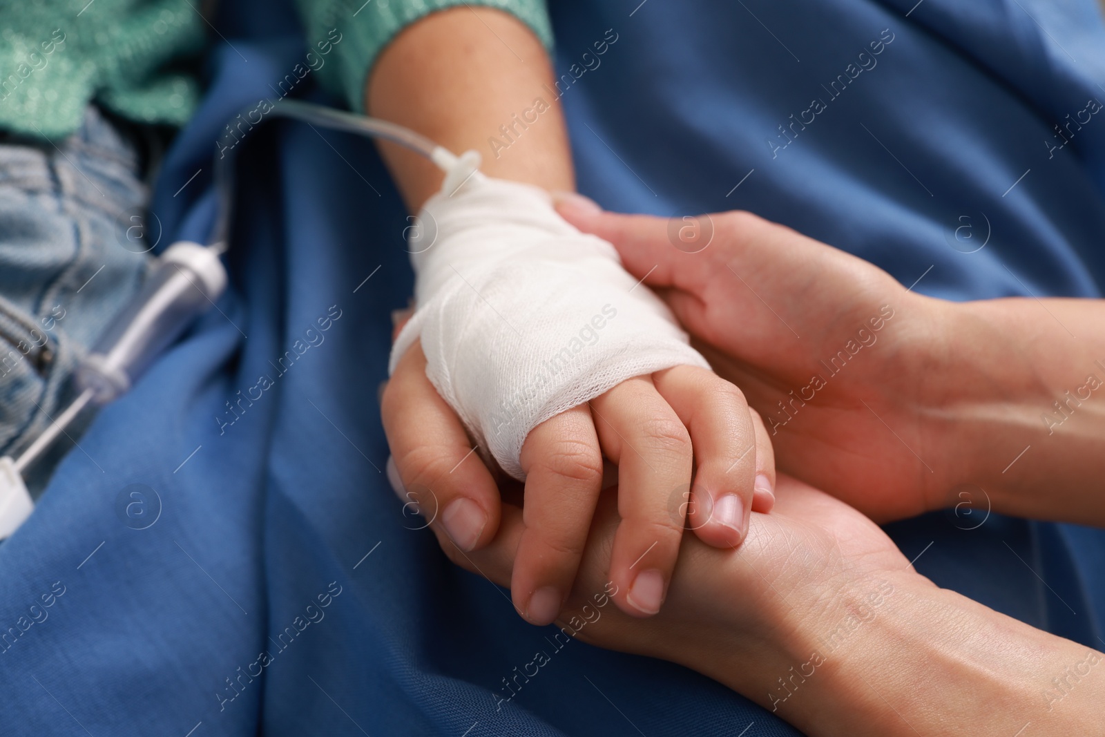 Photo of Doctor and child with IV drip in hospital, closeup