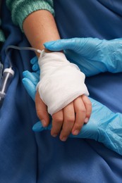 Photo of Doctor and child with IV drip in hospital, closeup