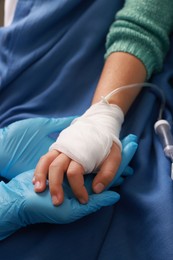 Photo of Doctor and child with IV drip in hospital, closeup